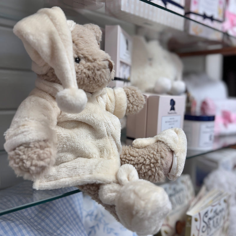 Mon Ami teddy bear in a bathrobe and slippers on a glass shelf