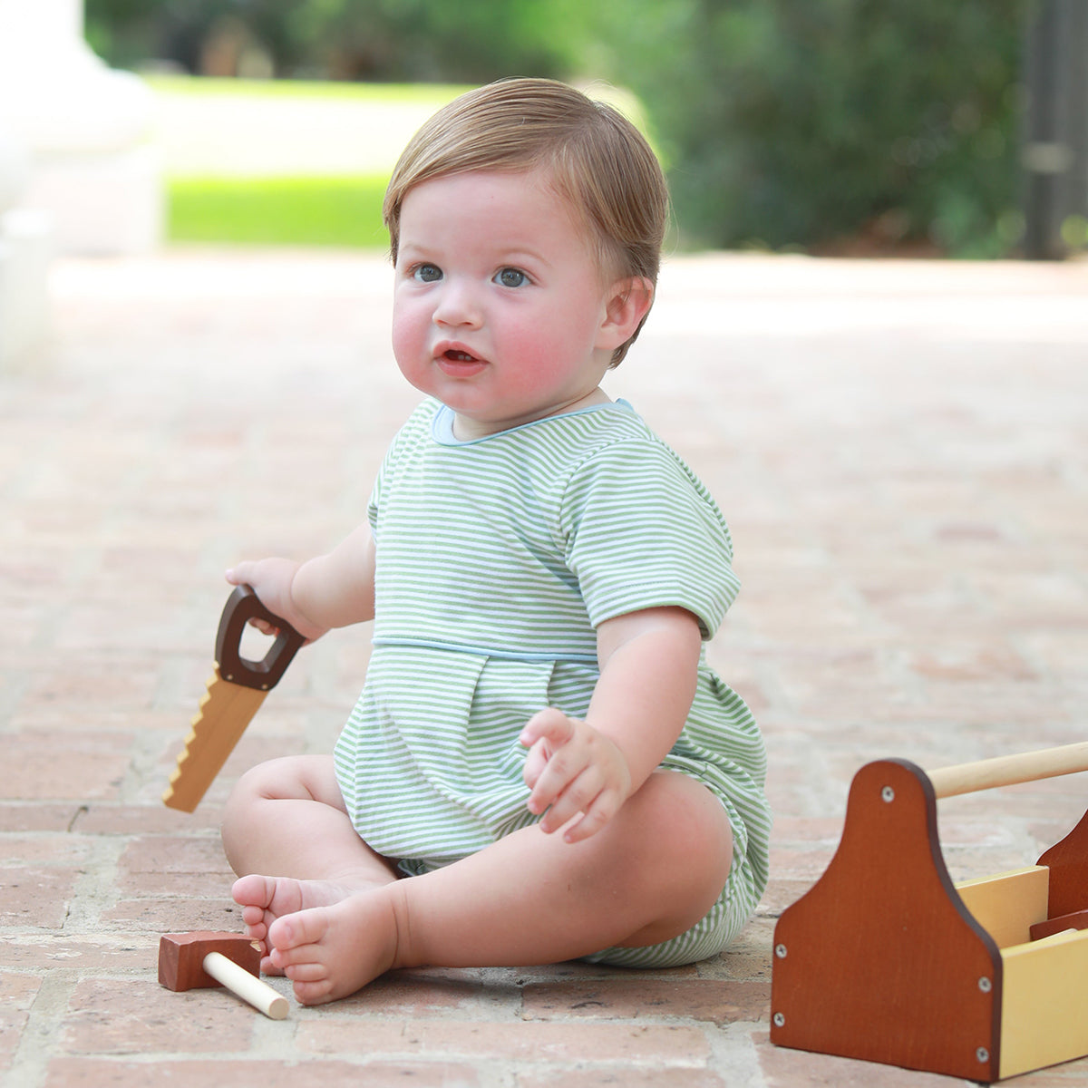 Baby boy wearing a green striped knit bubble with light blue trim