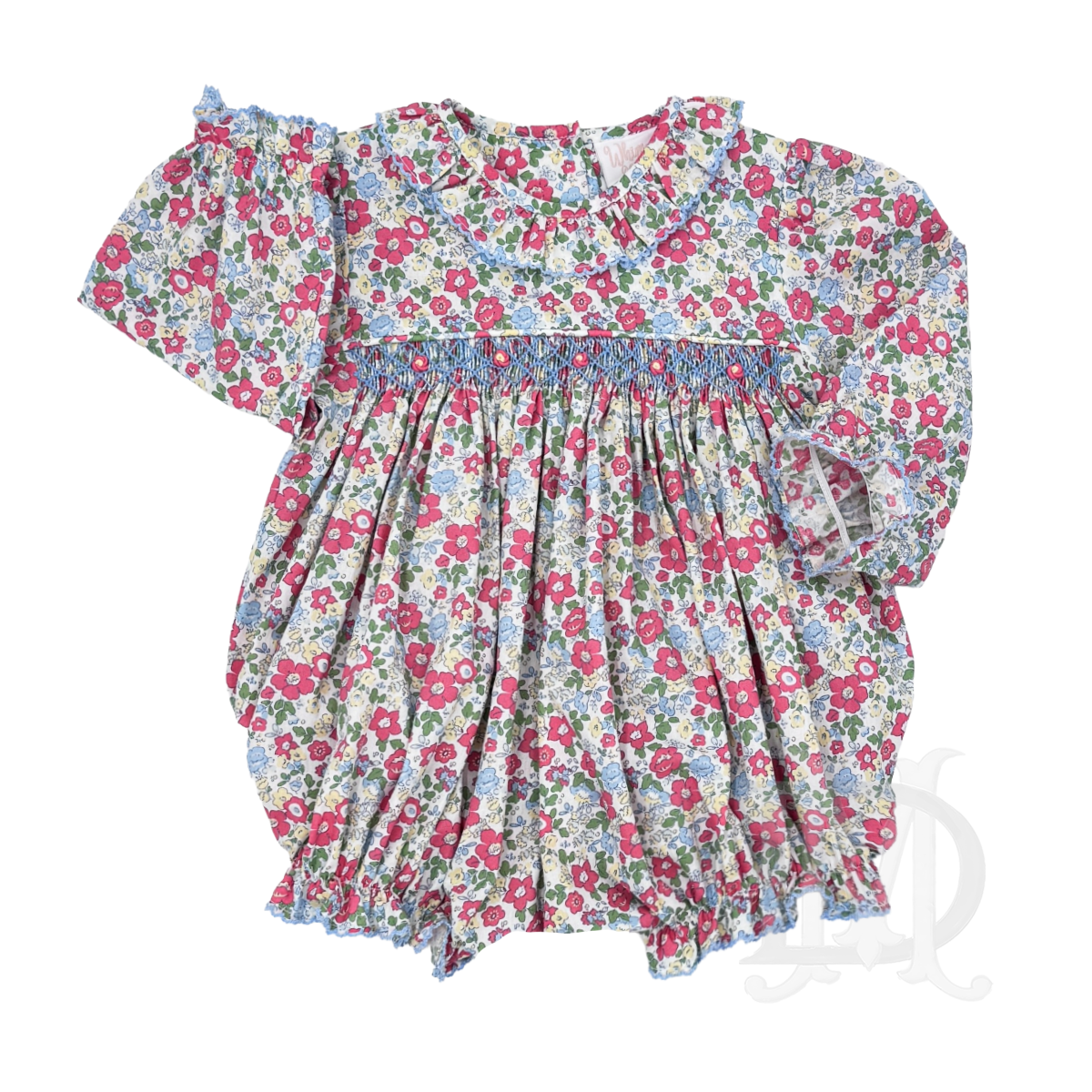 A long-sleeve baby girl bubble in a pink, red, and blue floral print with smocking and a ruffled collar.