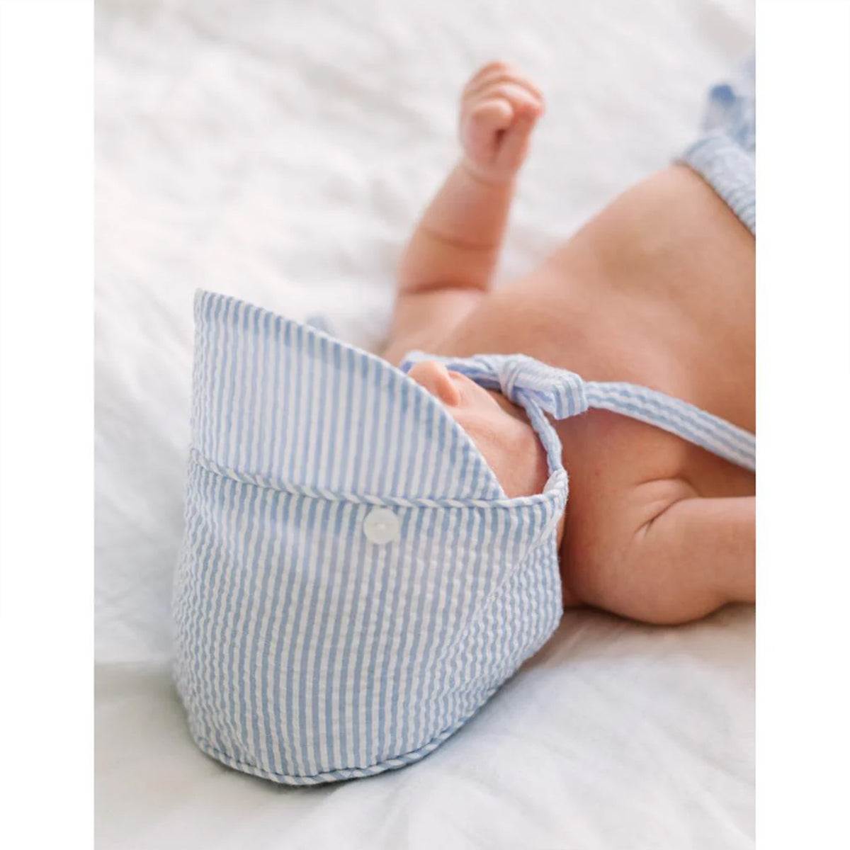 Baby boy wearing a blue and white striped diaper cover and classic seersucker bonnet.