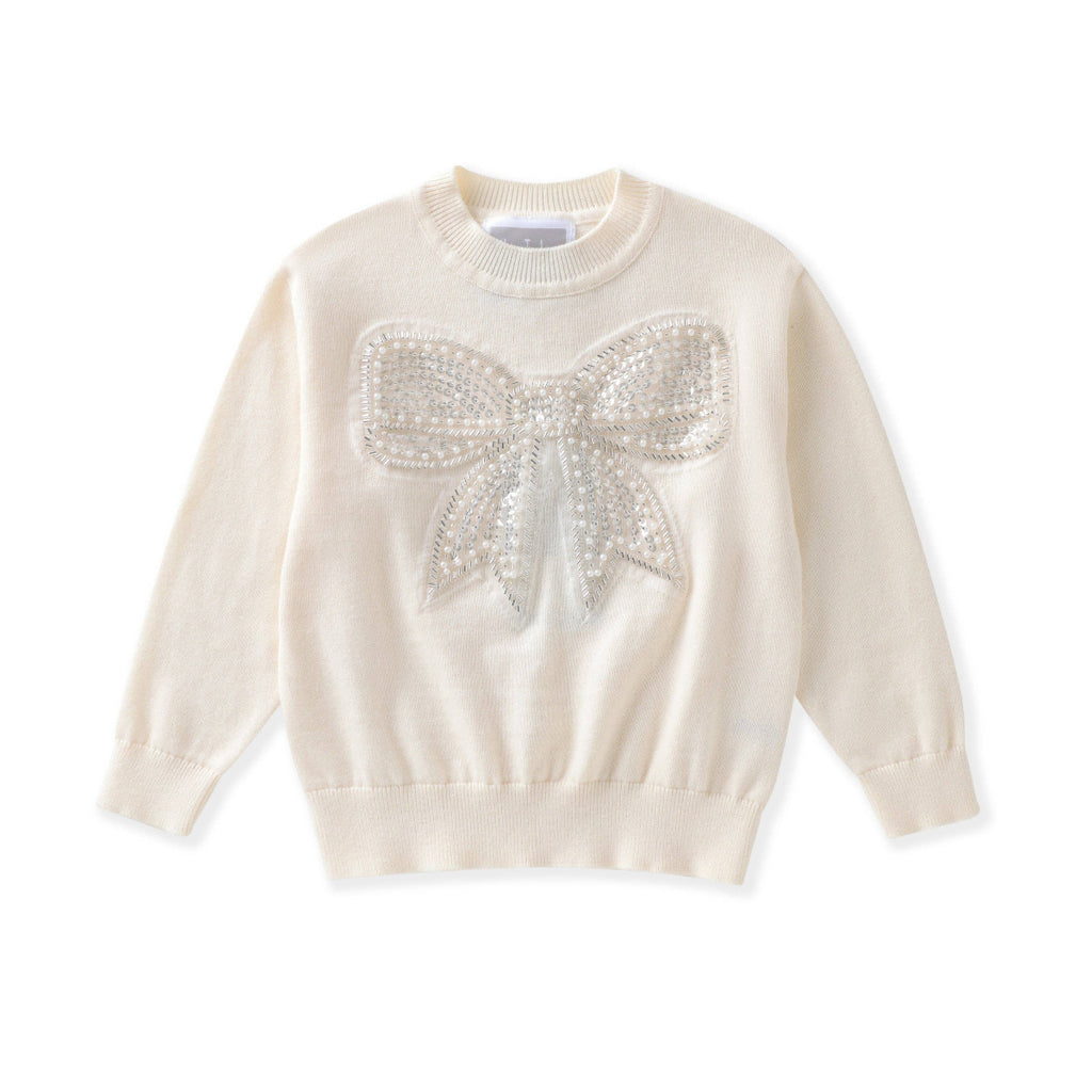 An off-white long-sleeve knit sweater featuring a large, textured bow embellished with shimmering silver rhinestones on the chest, displayed against a solid white background.