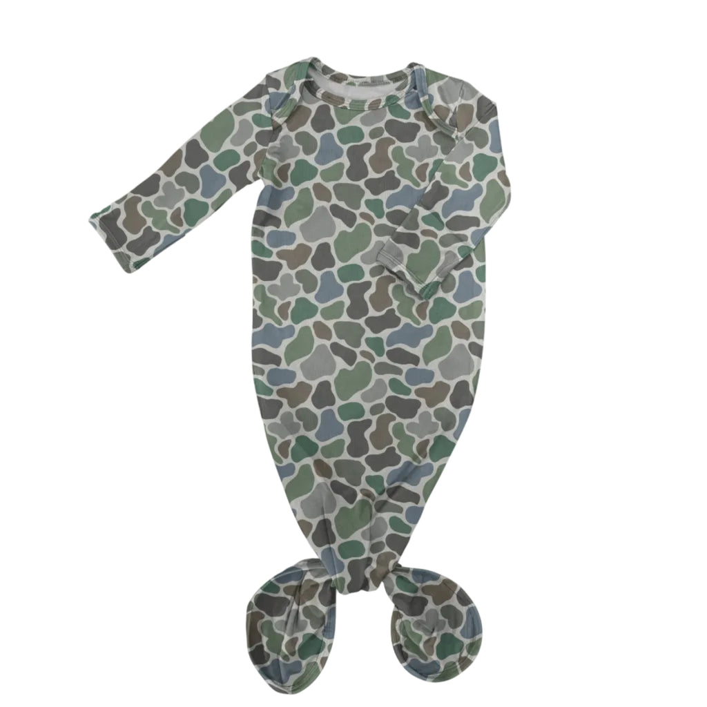 A baby footed sleeper with a long-sleeve design, featuring an all-over organic camouflage pattern in shades of green, gray, and brown on a light gray base, with the feet knotted together at the bottom.