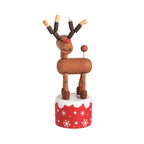 Wooden collapsible toy Christmas reindeer figurine on a red and white snowflake base