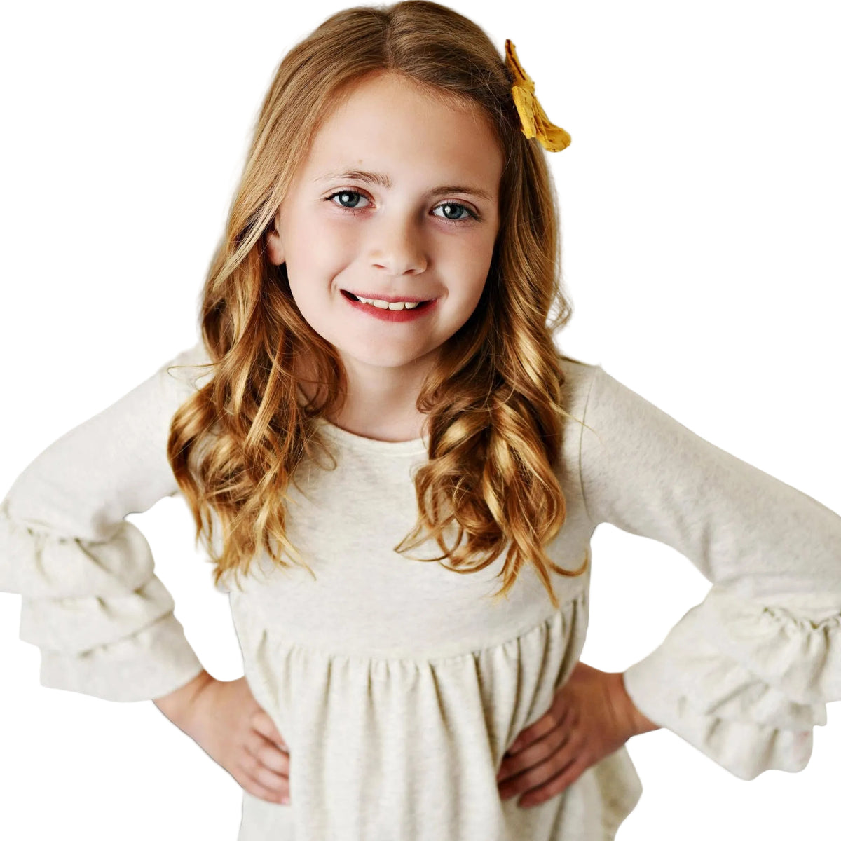 Young girl wearing a white blouse with ruffled sleeves against a gray background