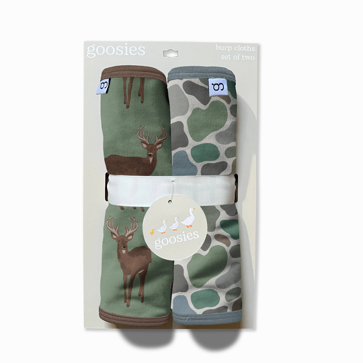 Packaged baby booties with deer and camouflage patterns on a white background