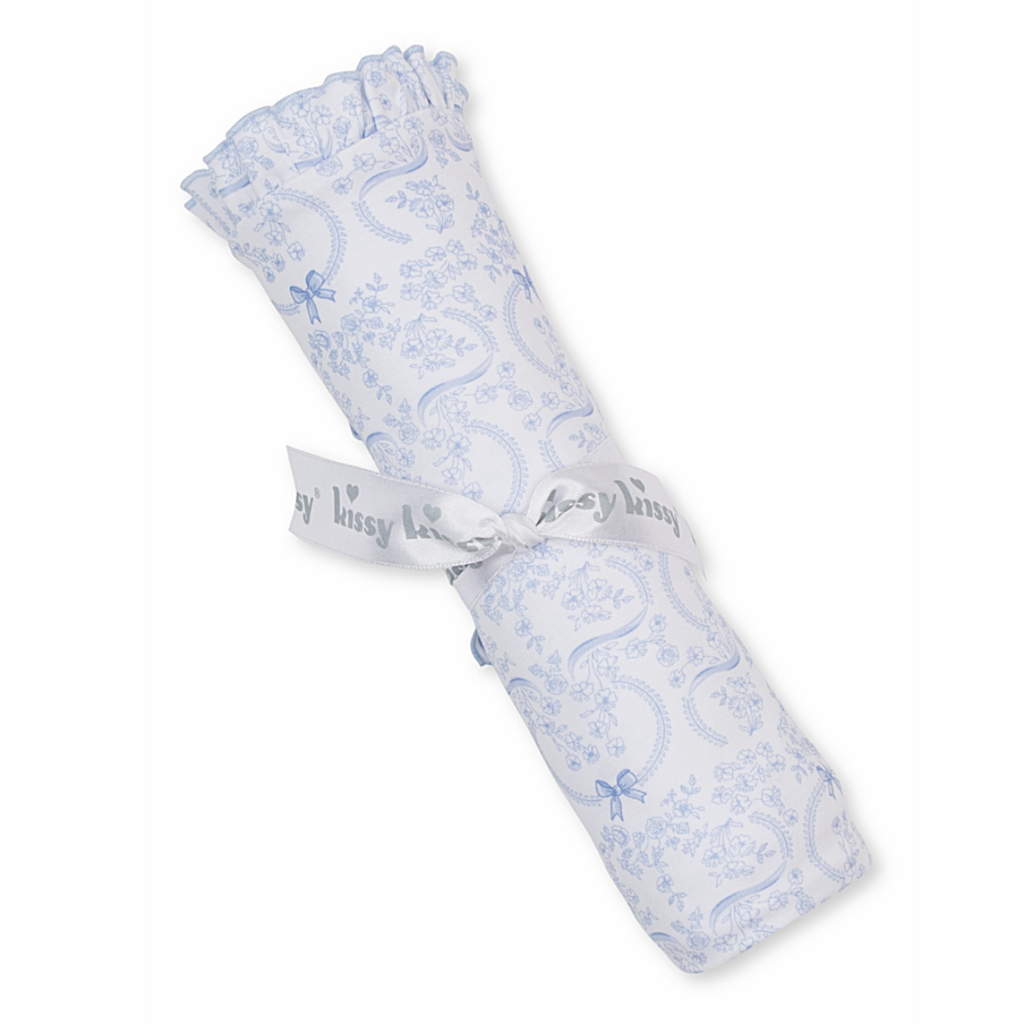 Rolled-up baby blanket with blue coquette bows and floral pattern with ruffle trim.