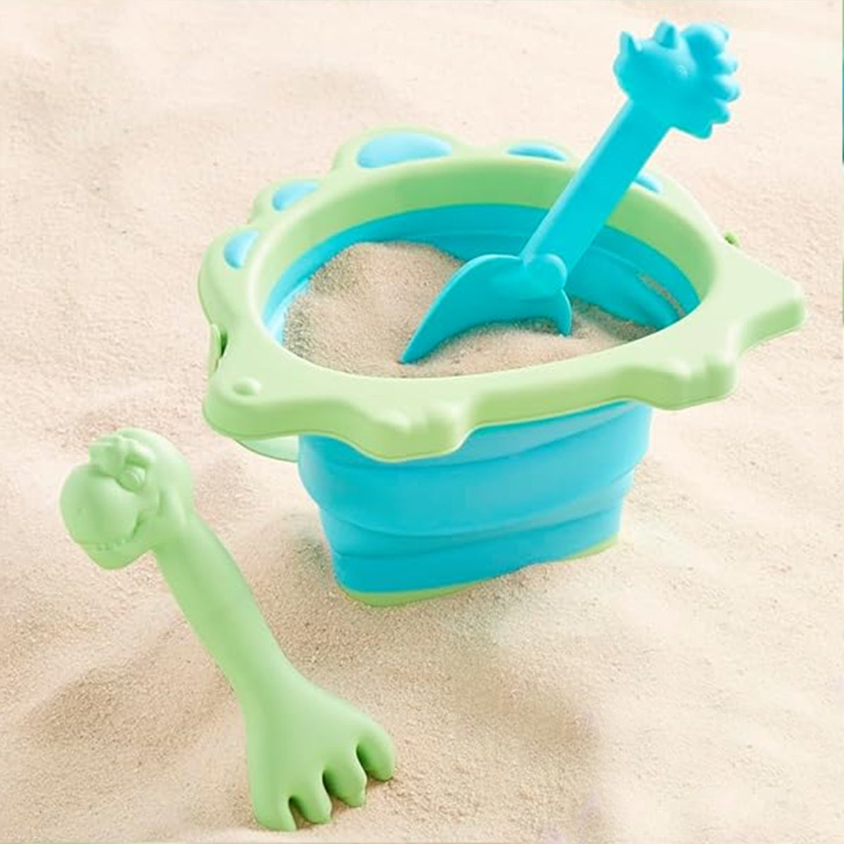 Dinosaur-themed collapsible sand bucket beach toy with shovel and rake