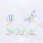Close up of hand embroidered greenery and dragonflies.