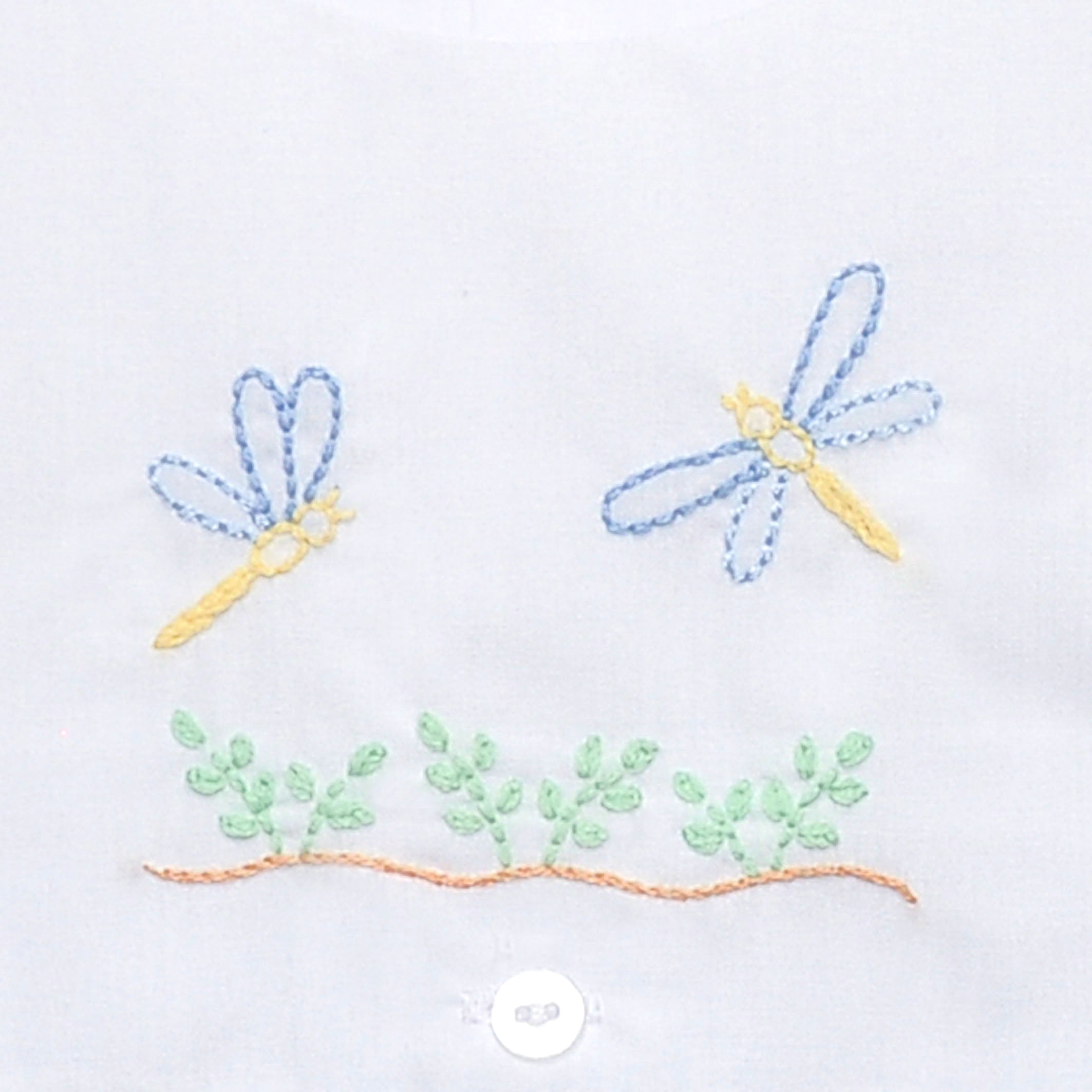 Close up of hand embroidered greenery and dragonflies.