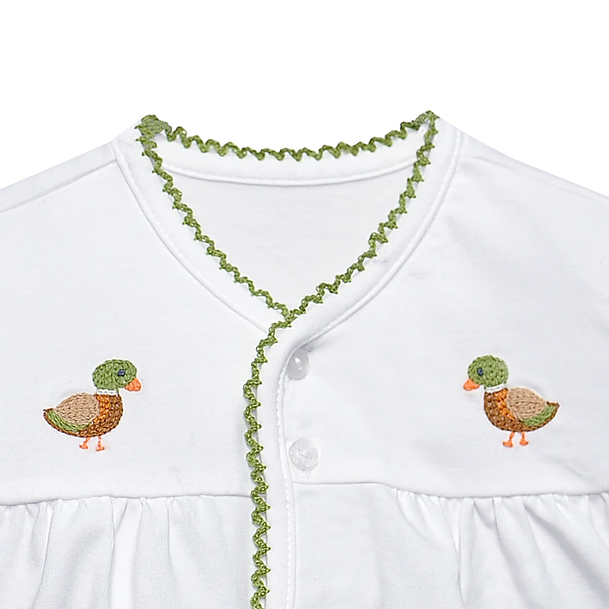 Close up view of a white baby two-piece diaper set consisting of a short-sleeve button-front top with green trim and embroidered duck motifs.