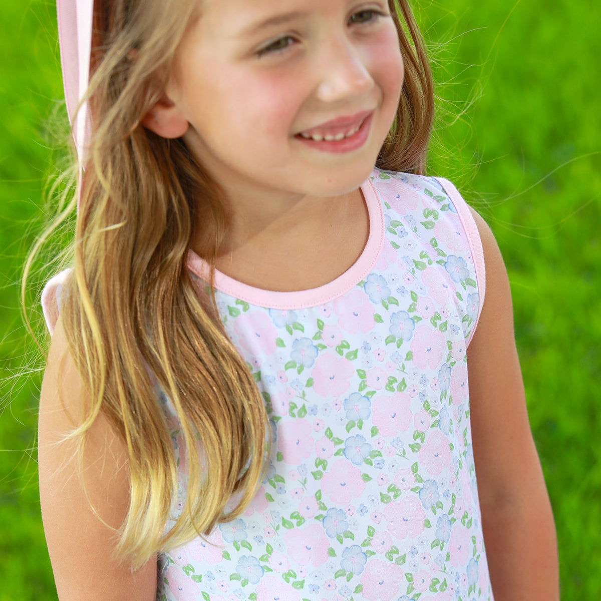 Girl wearing a floral knit sleeveless top with pink trim