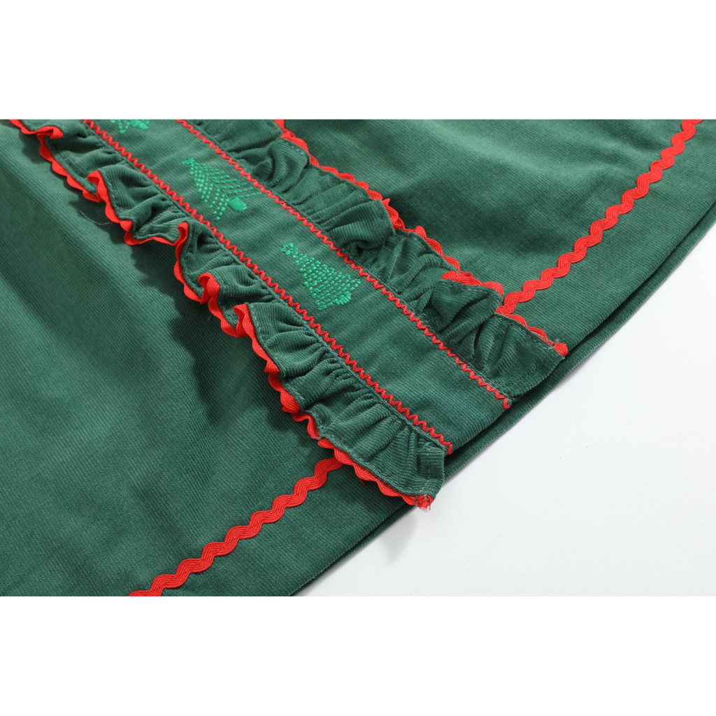 Close-up of a dark green fabric item with red scalloped trim and green embroidered details, laid on a white background.