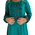 Teal dress with ruffles and buttons worn by a child against a neutral background