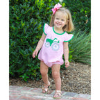 Toddler girl wearing a pink striped knit bubble one-piece outfit with flutter sleeves and a green tractor applique