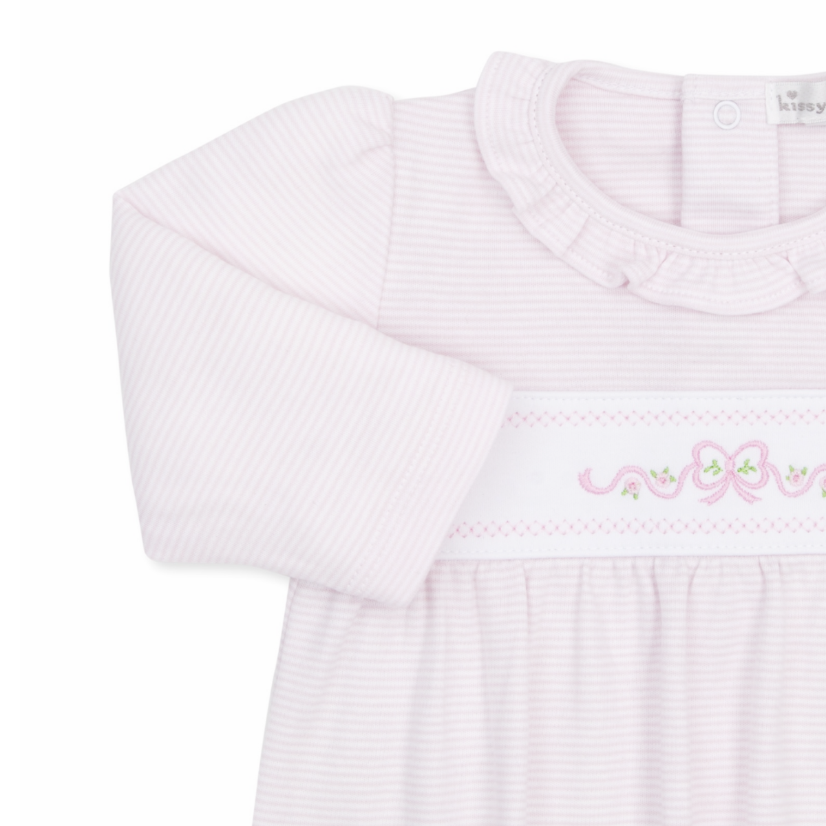 A close-up of a girl’s long-sleeve baby sack in pale pink and white stripes, featuring a ruffled collar and pink bow and floral embroidery.