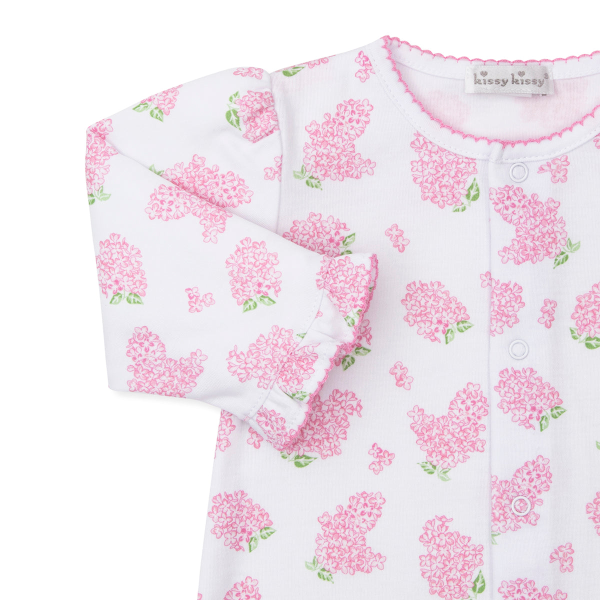 Closeup of baby girl converter gown with pink hydrangea floral pattern and Kissy Kissy brand label