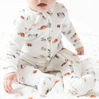 Baby boy wearing a cozy farm print footie with a zip front.