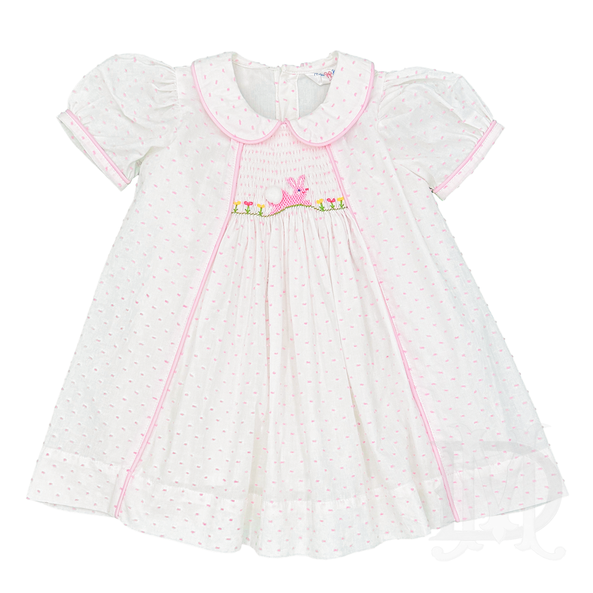 White toddler dress with pink Swiss dots and and embroidered pink bunny and flowers on a smocked plate