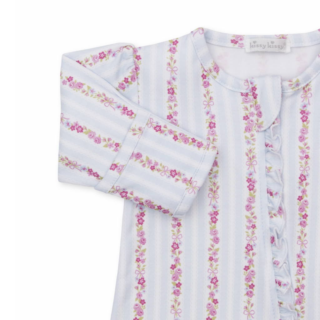 A baby girl footie sleeper closeup with a Kissy Kissy brand label featuring light blue and white vertical stripes with pink floral and bow patterns and a ruffled zipper down the front.