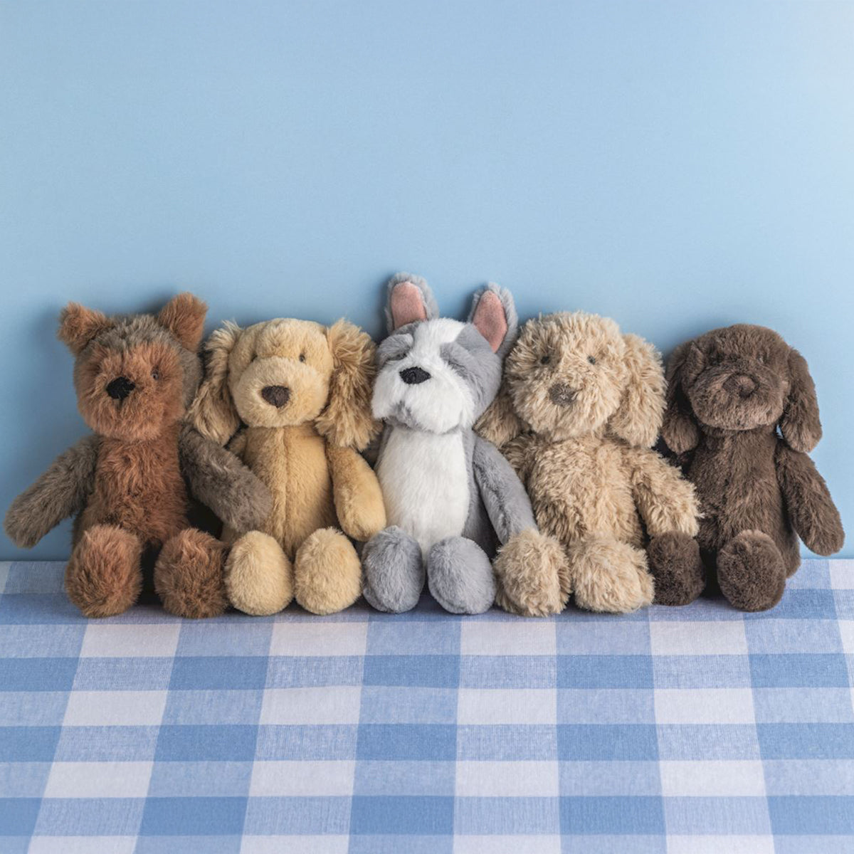 Yorkie, retriever, french bulldog, doodle, and lab mini plush puppy dog pals on a blue check seat.