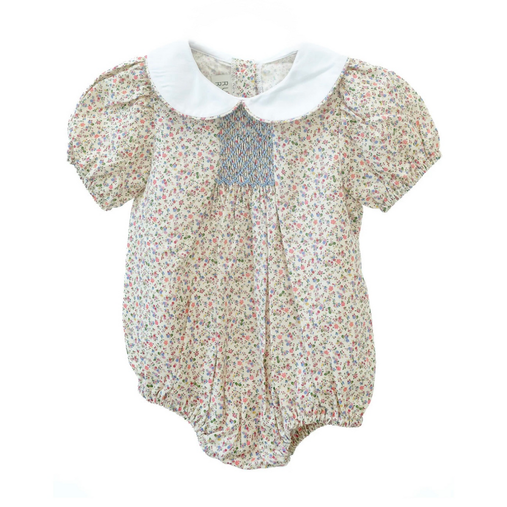 Baby girl cotton bubble with fall floral print, white Peter Pan collar, puff sleeves, smocked chest panel, elastic leg openings, and snap closure.