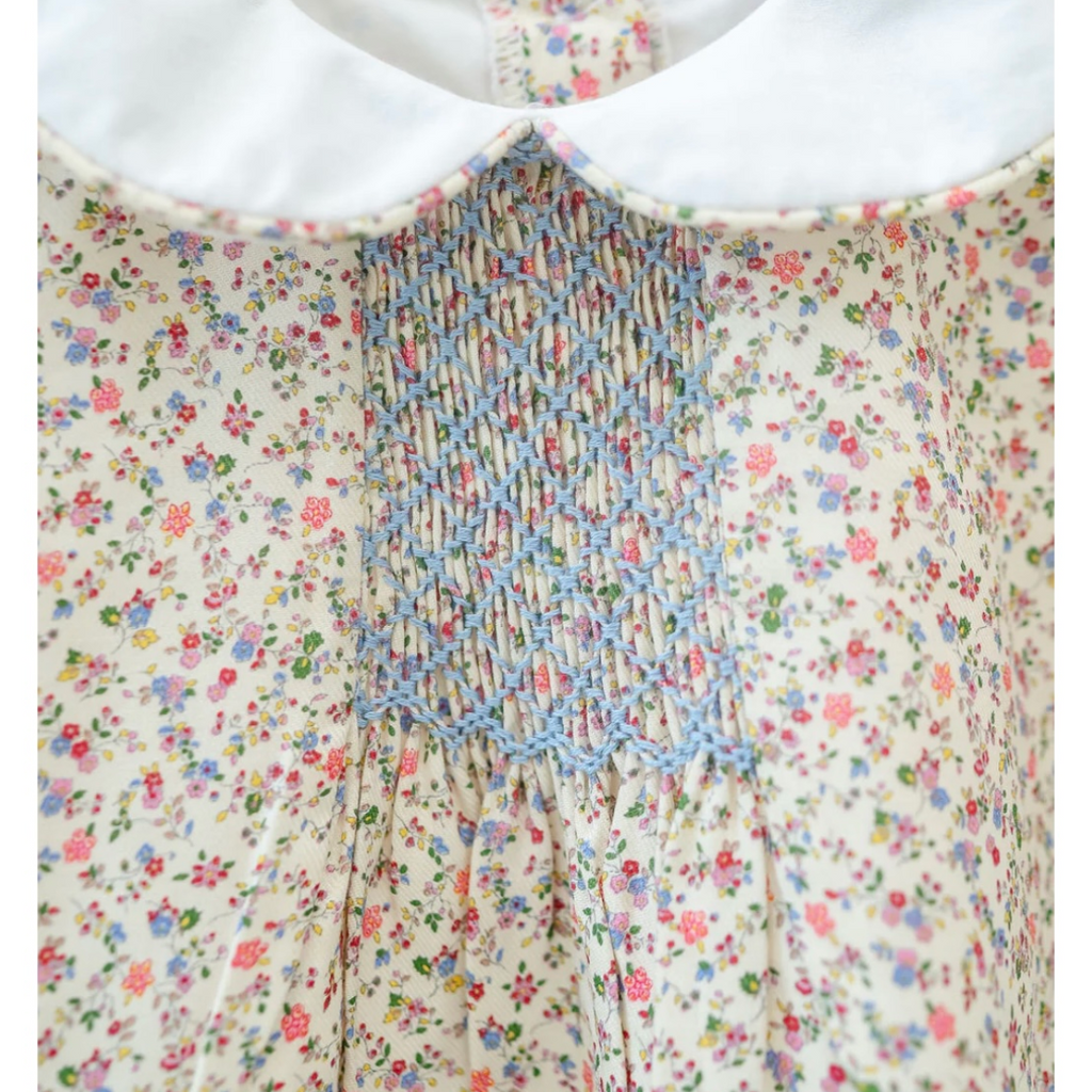 Fall floral print fabric with white Peter Pan collar and smocked chest panel in blue embroidery.