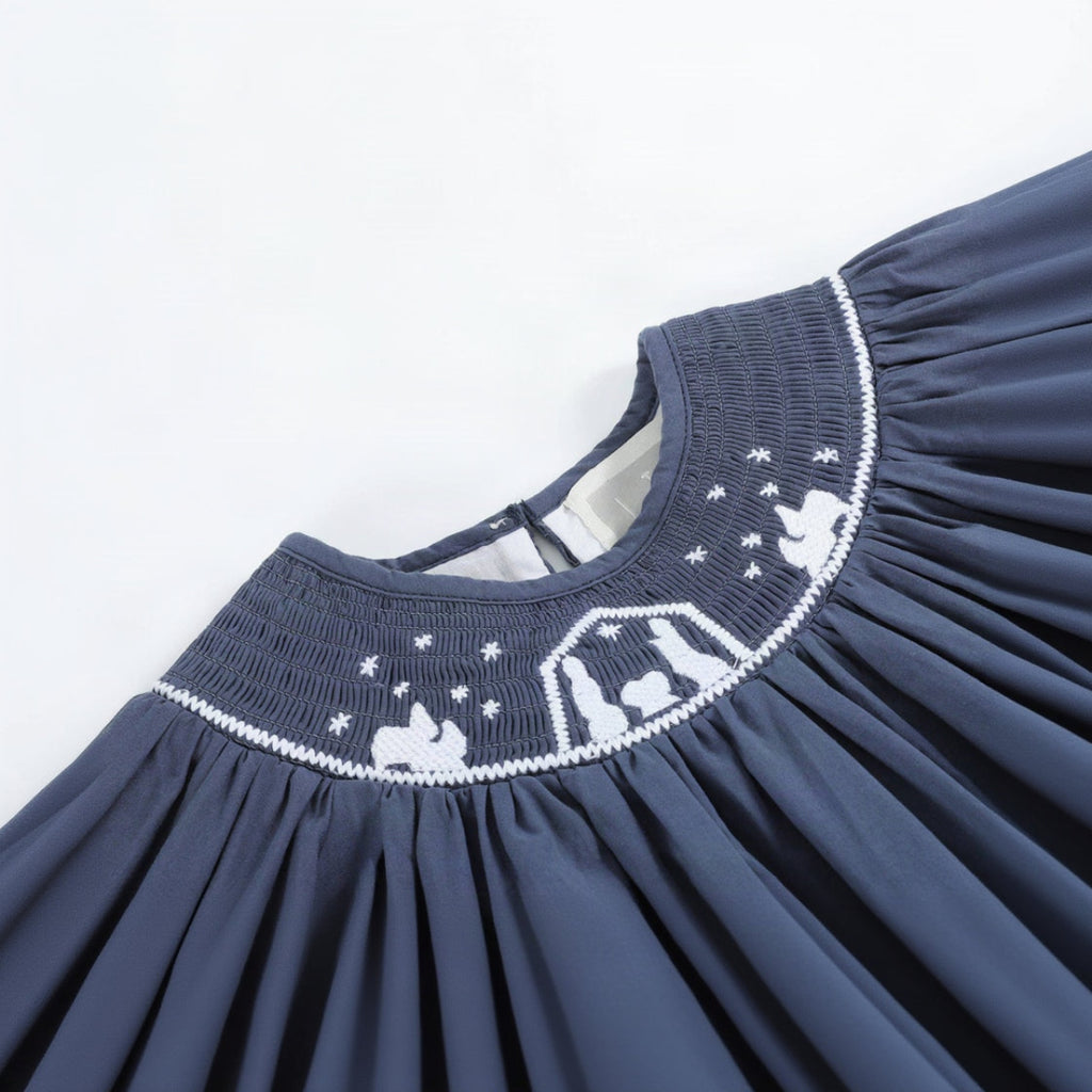 Navy blue dress with white embroidery on a light gray background