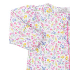 Closeup of a baby girl zip front footie with a bright floral pattern, ruffle trim, and Kissy Kissy brand label