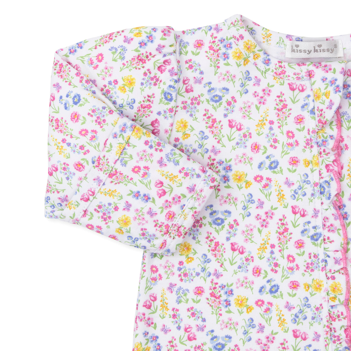 Closeup of a baby girl zip front footie with a bright floral pattern, ruffle trim, and Kissy Kissy brand label
