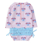 Back view of a baby girl long sleeve one piece swimsuit with patriotic American flag and bow pattern, zipper back, and ruffled bottom.