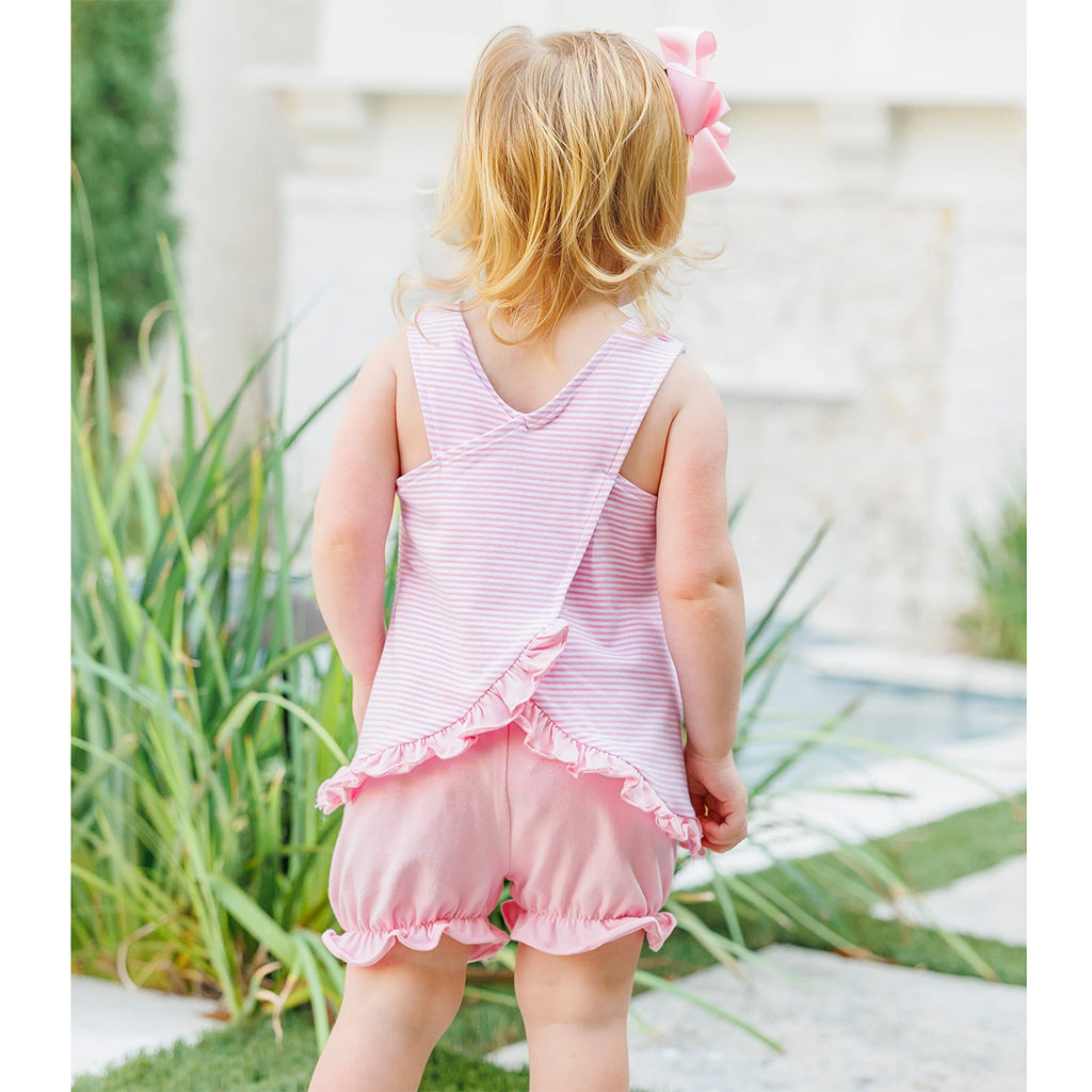 Little girl showing the back of a light pink striped sleeveless bloomer set with ruffles.