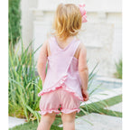 Little girl showing the back of a light pink striped sleeveless bloomer set with ruffles.