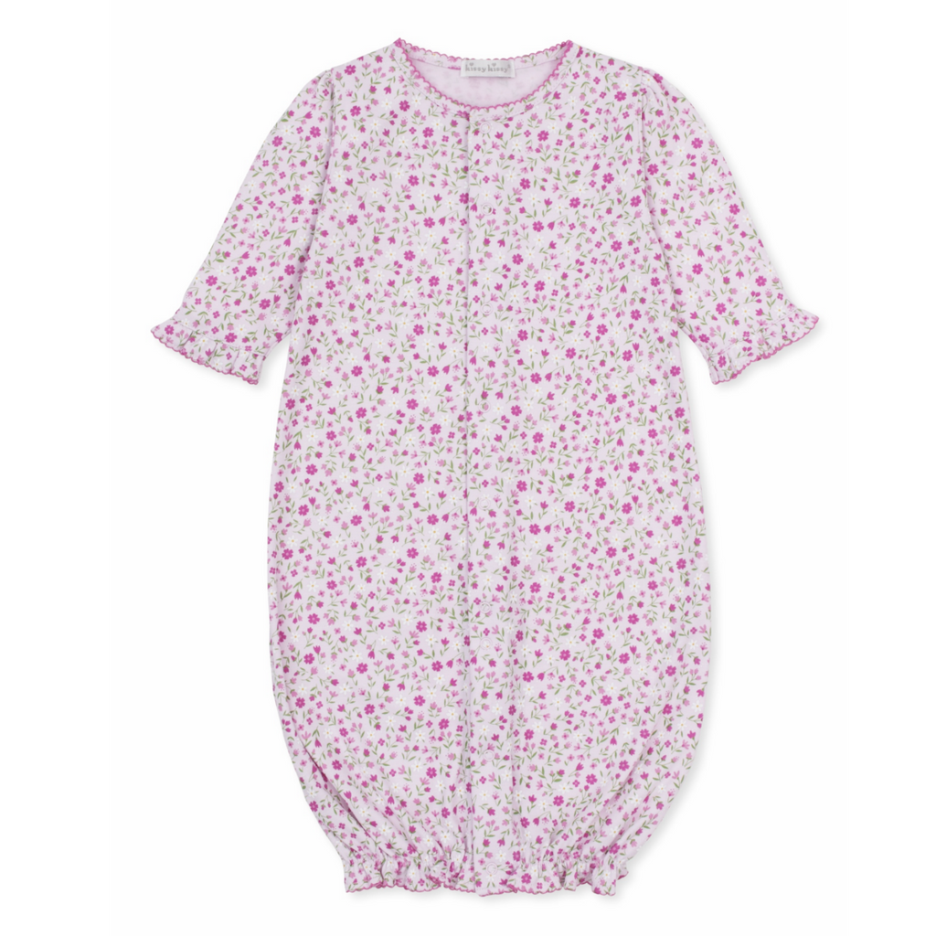 A baby girl pink converter gown with a floral print, hot pink trim, and ruffles at the wrists. 