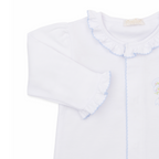 A white long-sleeve baby girl sleep sack with ruffled collar and cuffs, light blue trim and a delicate embroidered bow with pink rosettes. 