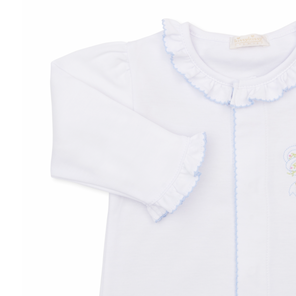 A white long-sleeve baby girl sleep sack with ruffled collar and cuffs, light blue trim and a delicate embroidered bow with pink rosettes. 