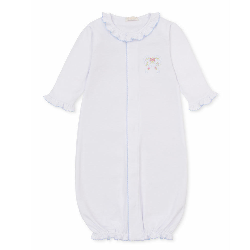 A white long-sleeve baby girl sleep sack with ruffled collar and cuffs, light blue trim and a delicate embroidered bow with pink rosettes. 