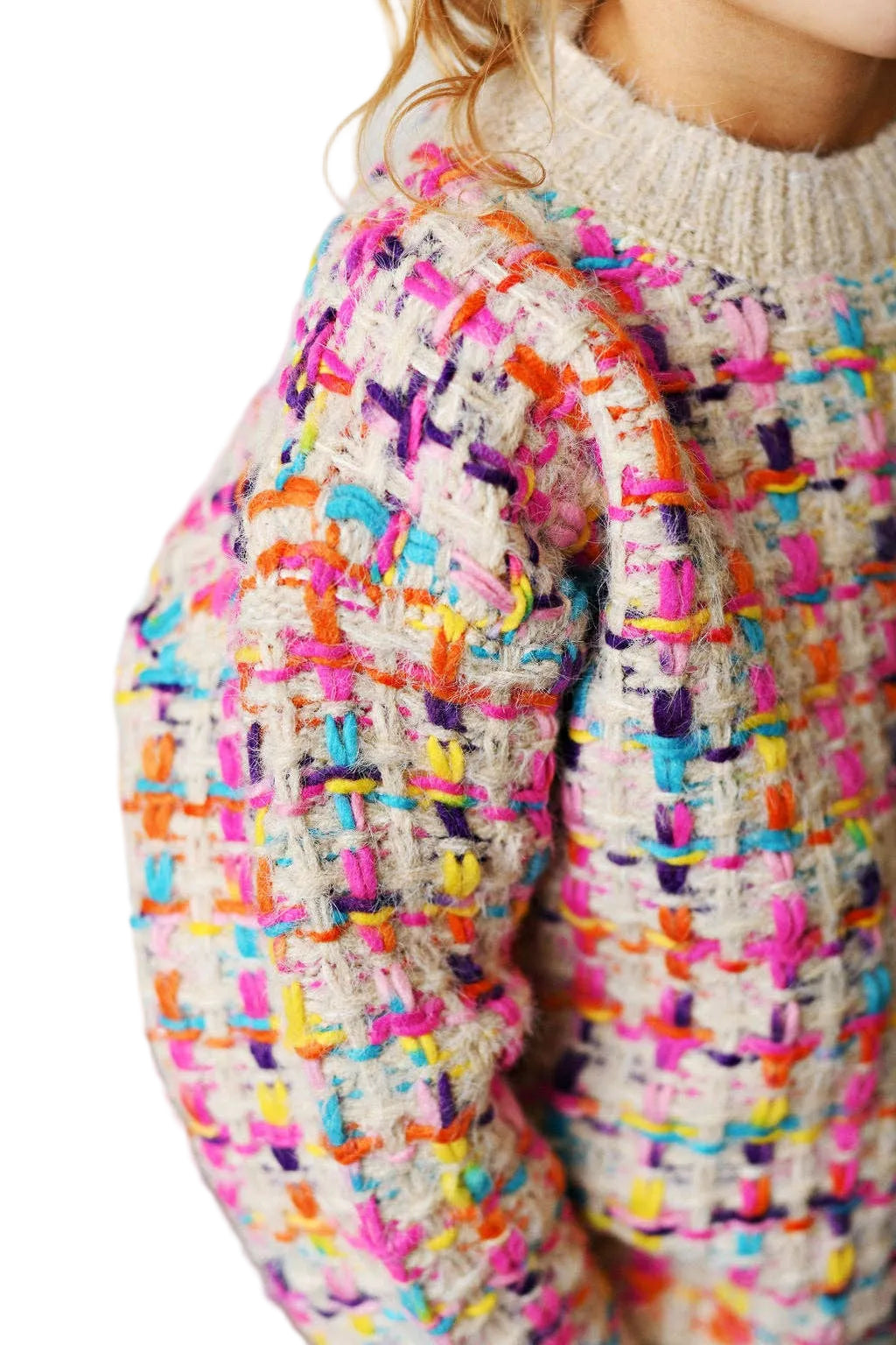Close-up of a colorful textured sweater with a neutral background