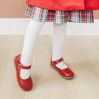 Little girl wearing red Mary Jane shoes and white sock