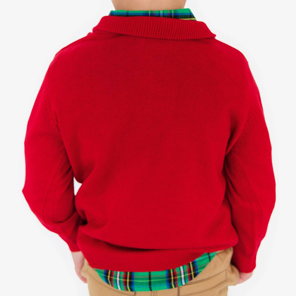 Child wearing a red sweater over a plaid shirt on a white background