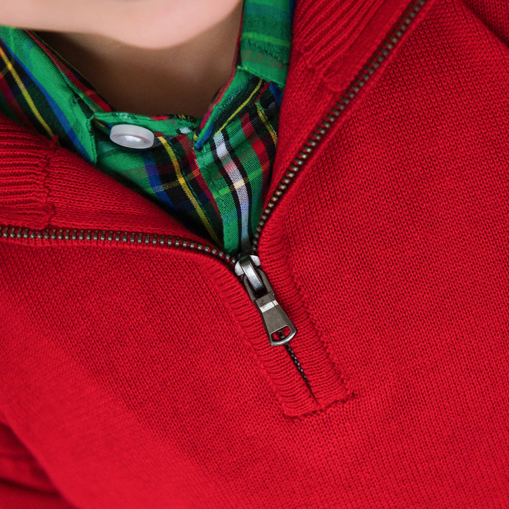 Close-up of a red sweater with a zipper and plaid collar.
