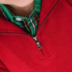 Close-up of a red sweater with a zipper and plaid collar.
