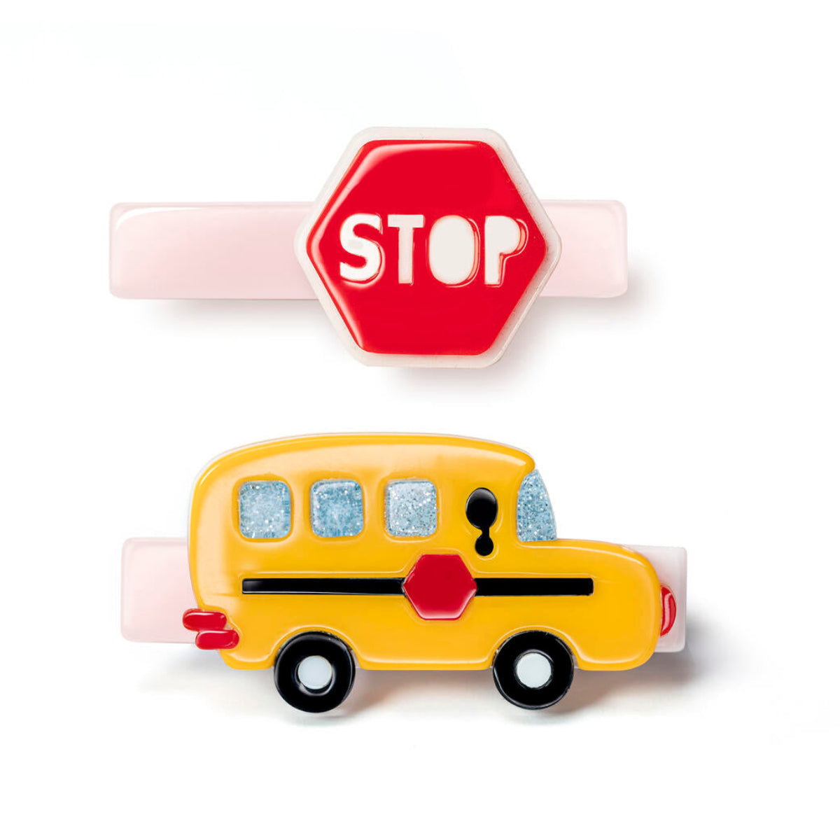 Two acrylic hair clips - one a red stop sign and one yellow school bus, both on pale pink bases.