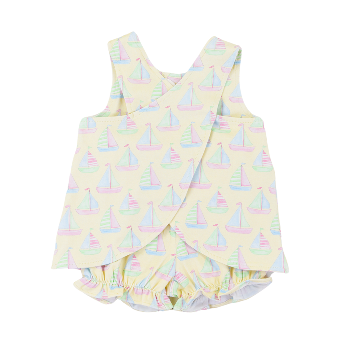 The criss cross back of a girls pale yellow summer bloomer set with a pastel sailboats print design.