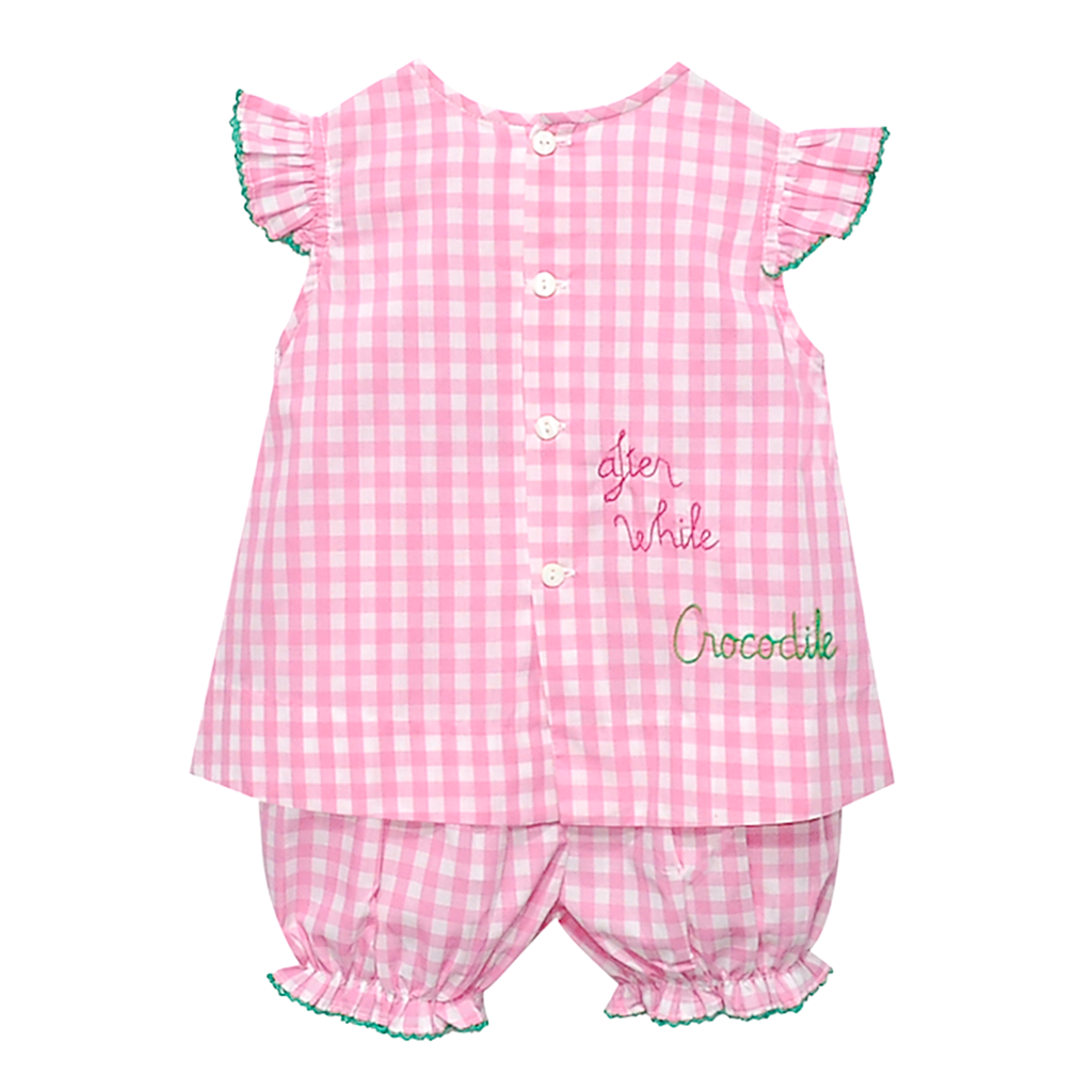The back view of a baby girl pink bloomer set outfit embroidered with "after while crocodile".