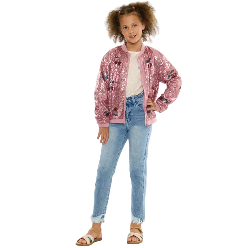 Young girl wearing a pink sequin jacket and blue jeans on a white background