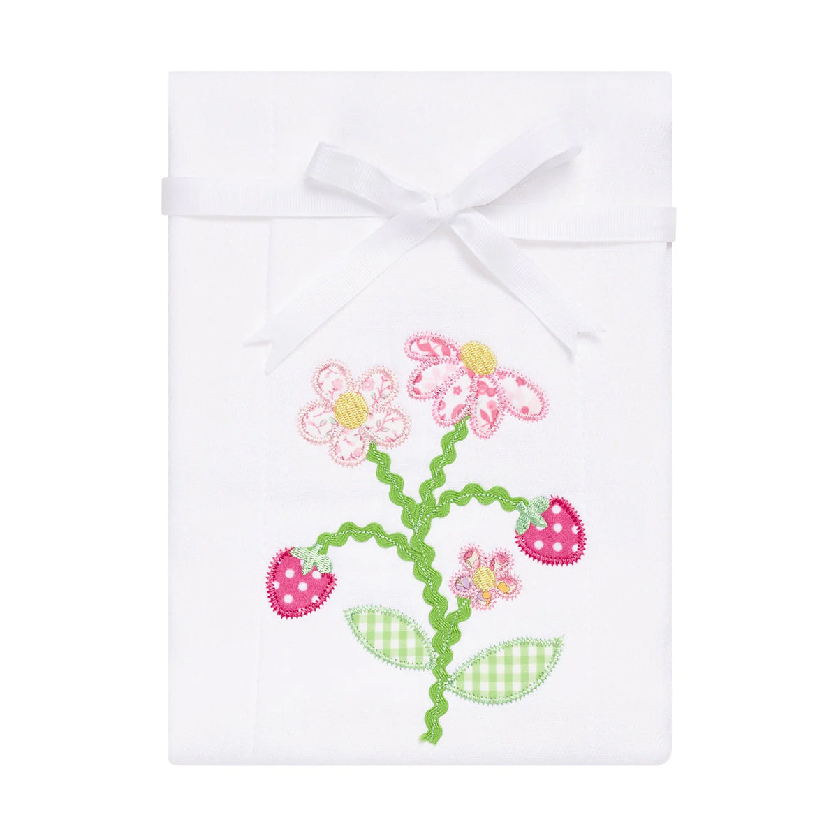 White baby burp cloth with pink strawberries and flowers applique tied with a white grosgrain ribbon for gifting