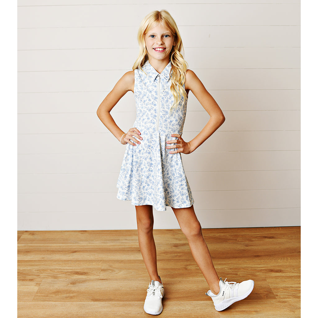 Young girl wearing a blue chintz floral zip-front tennis dress