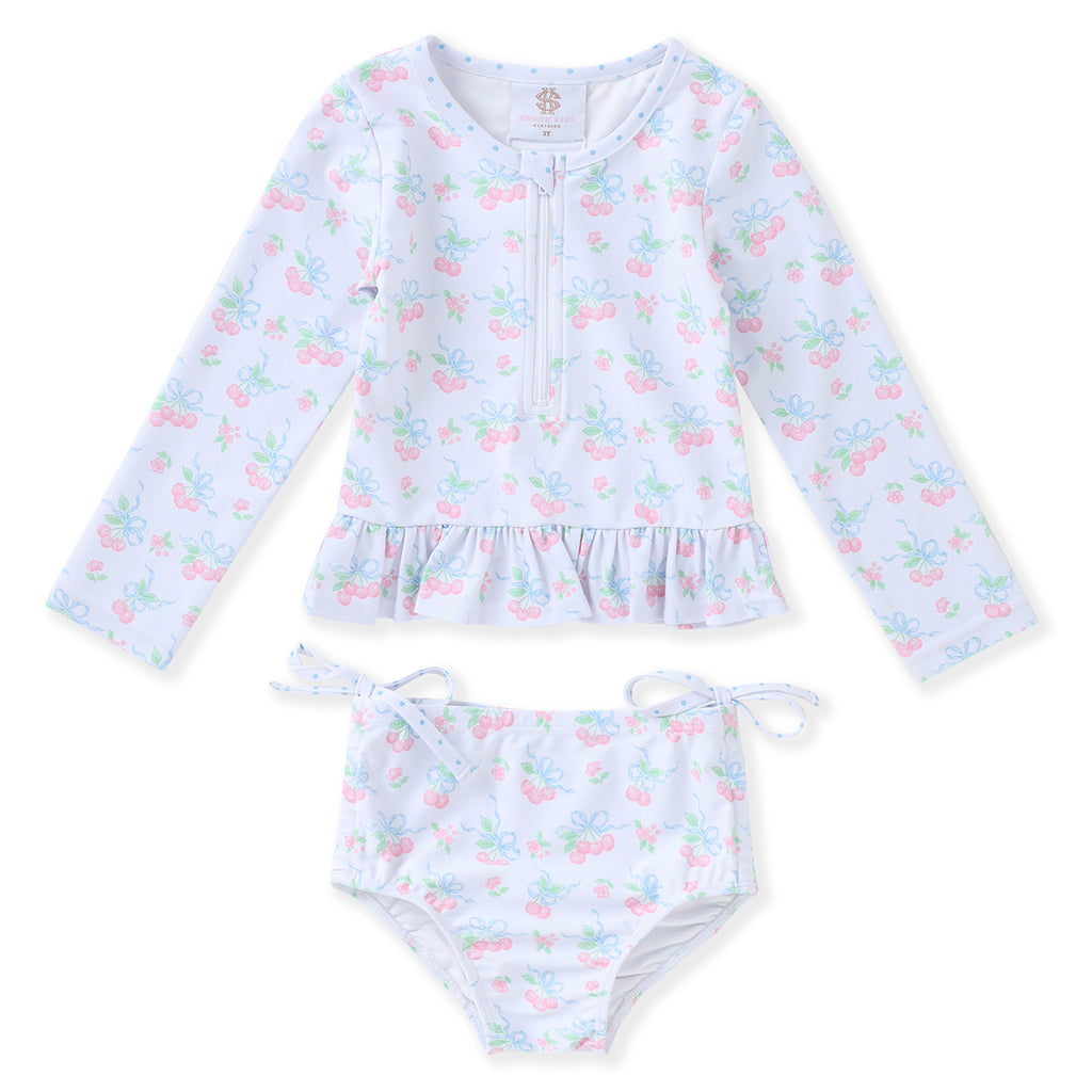 Girl's two-piece swimsuit with long-sleeve top and matching bottoms in a pink cherries print.