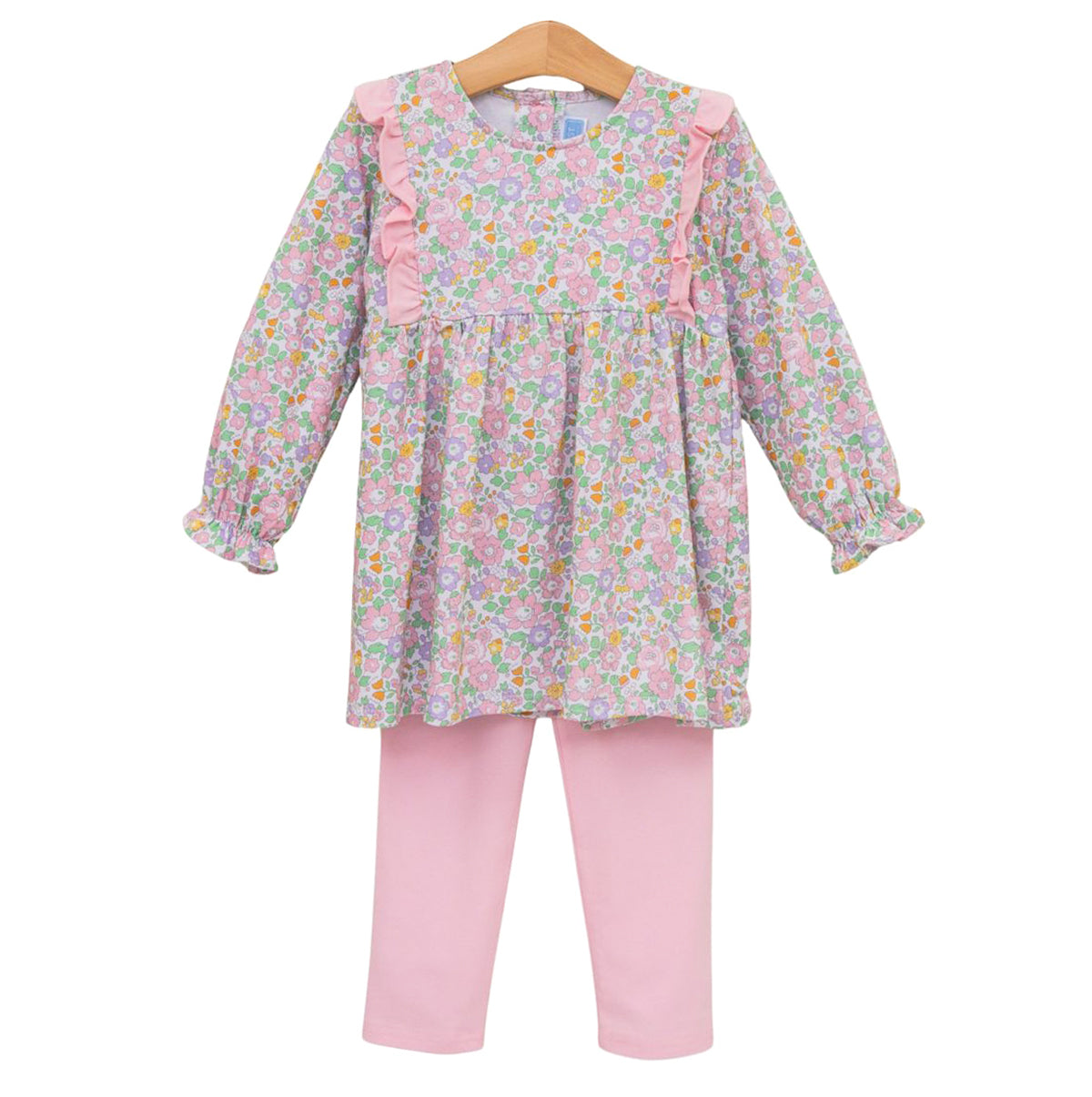 A little girl's two-piece outfit featuring a long-sleeve floral tunic top with pink ruffle details paired with solid light pink leggings.