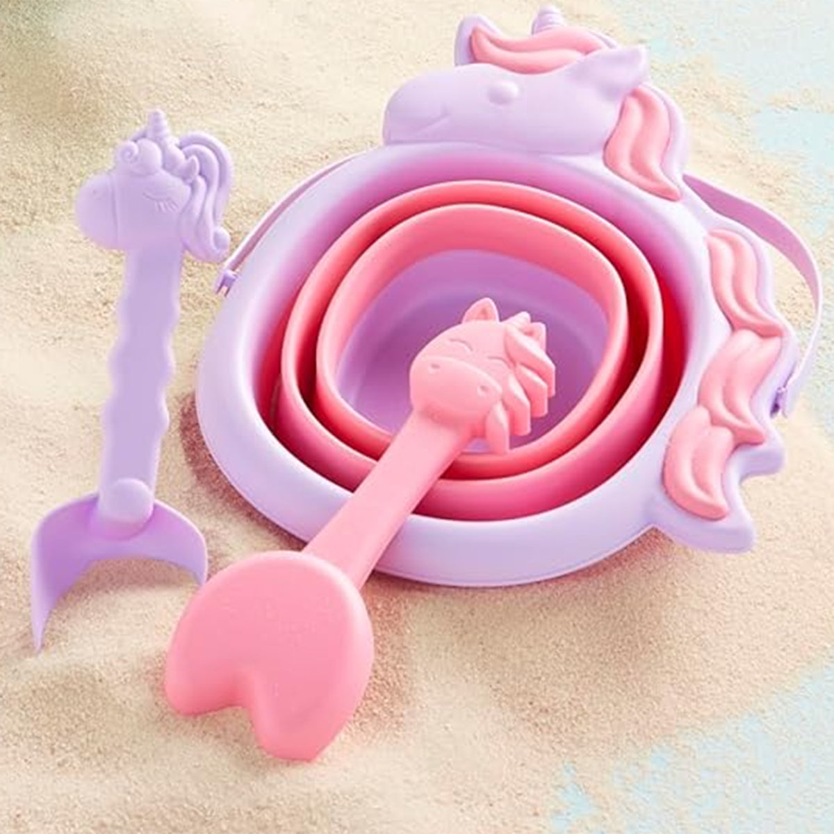 Collapsible purple sand bucket with unicorn design and pink shovel and rake.